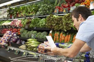 Man in supermarket looking at his list