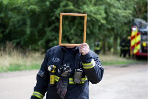 Man holding up mirror in front of face so his identity is obscured
