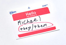 Une étiquette nominative sur laquelle on peut lire « Hello my name is... » Sous le nom Michael est écrit à la main et les mots « ils/eux » sont écrits à la main et encerclés.