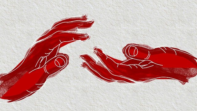 Une main rouge abstraite tend la main vers une autre.