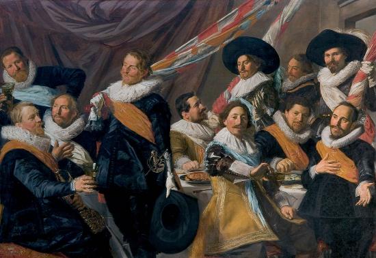 Several men at a dinner table eating and drinking while holding flags