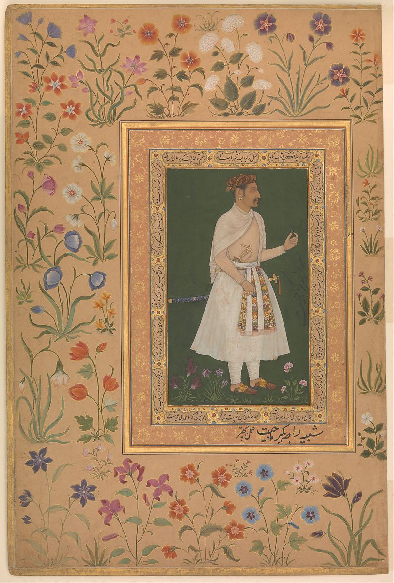 A man dressed in white surrounded by flowers