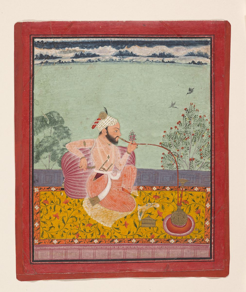 A man using a hookah on a yellow carpet