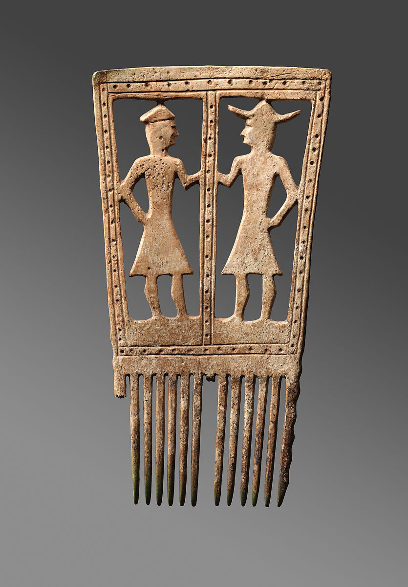A wooden comb carved with two figures
