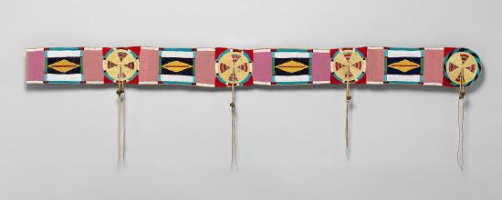 A blanket strip of leather, beads and paint in a repeating pattern