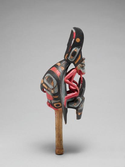 A wooden rattle carved and painted with colors