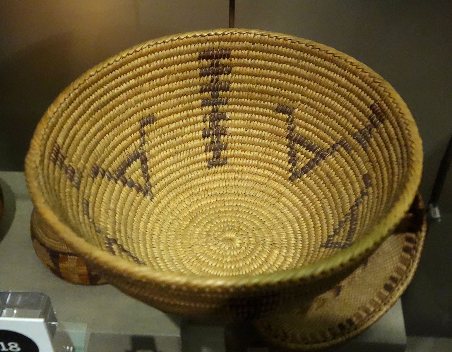 Miwok basket woven in two colors with a few geometric shapes