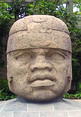 一张照片显示了一个巨大的雕刻石头，鼻子扁平，嘴唇大，眼睛稍微交叉。