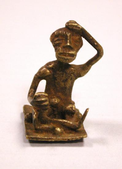 a man sitting with his legs crossed and his one arm on top of his head