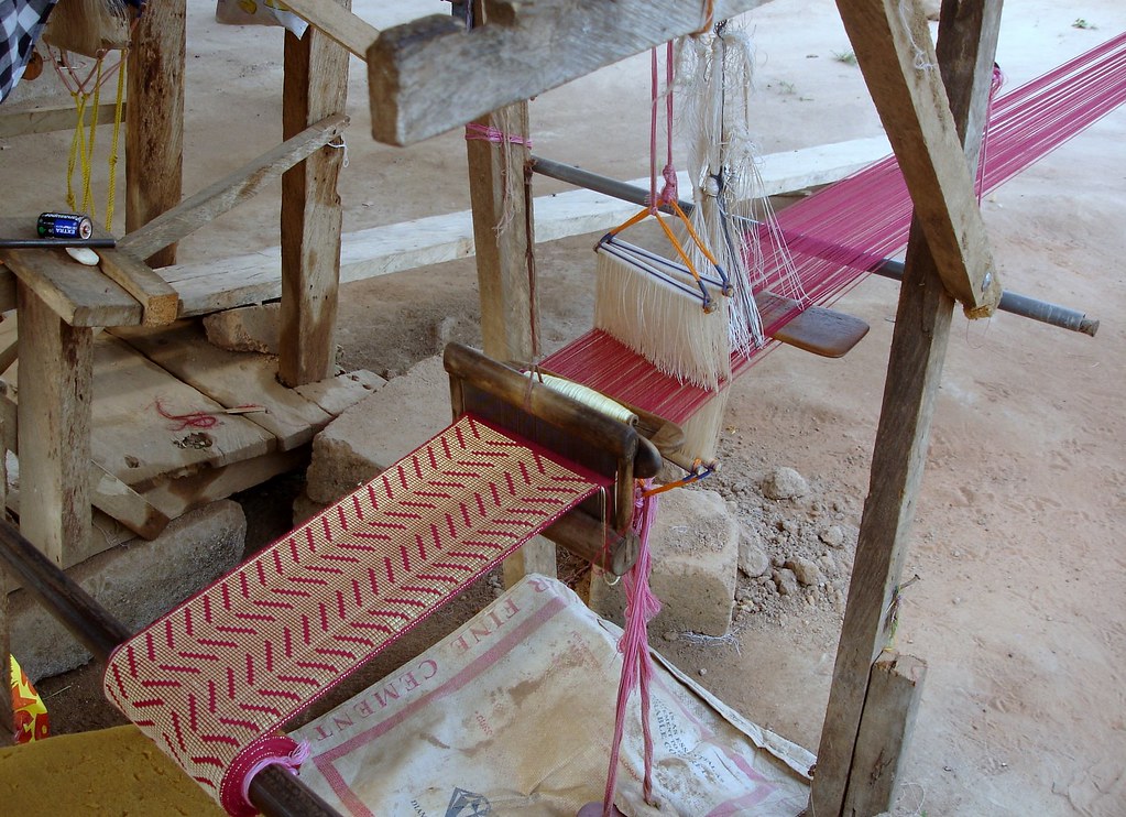 a weaving loom with pink and white colors 