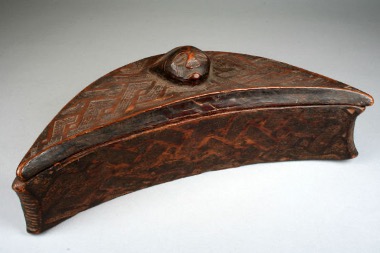 a wooden box shaped like a crescent with small round pull knob on top