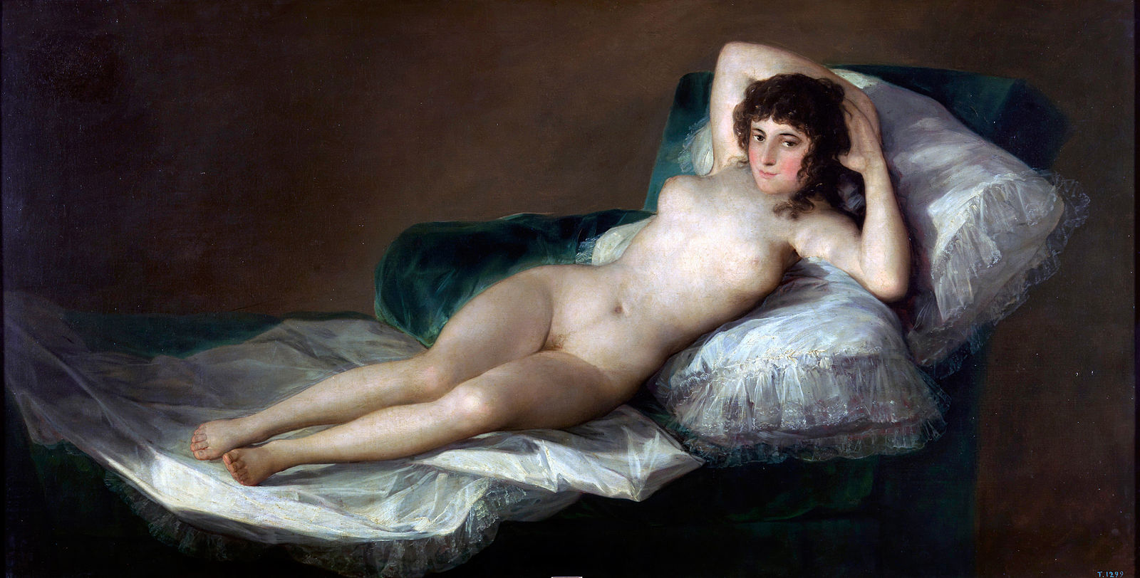 A nude woman reclining on a bed with white linen