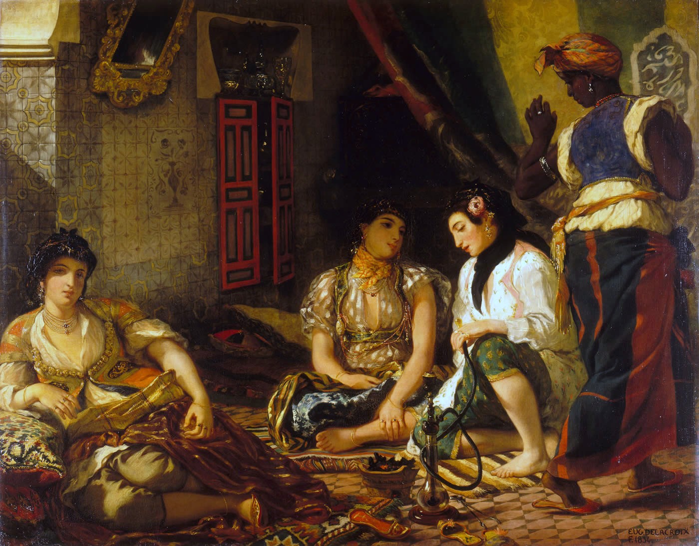 Three woman sitting on the floor while one woman is standing waiting on the others