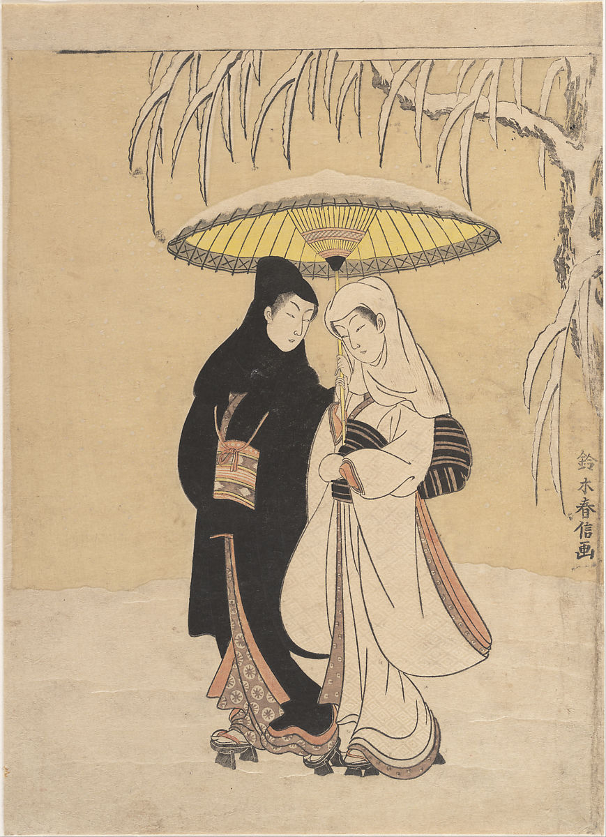 Two people walking in the snow with an umbrella