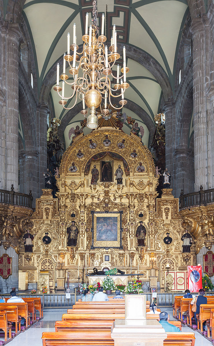 Ornate religious church altar in gold and several paintings