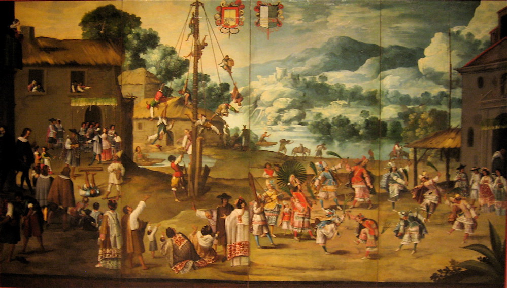 A wedding scene with several people, the bride and groom and a pole with people flying around it.