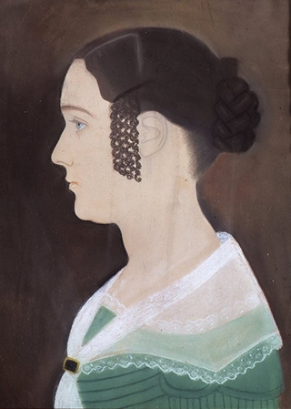 Side portrait of a woman with brown hair wearing a green dress