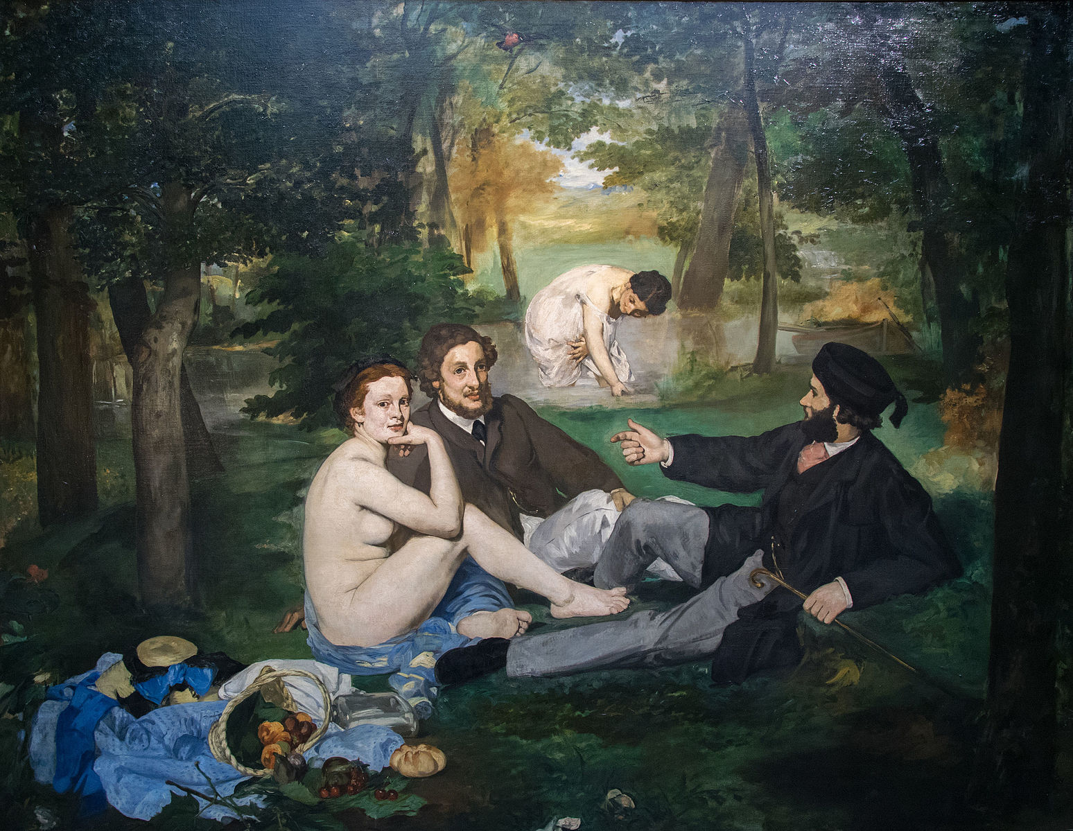 Dos mujeres y dos hombres haciendo un picnic junto a un pequeño estanque