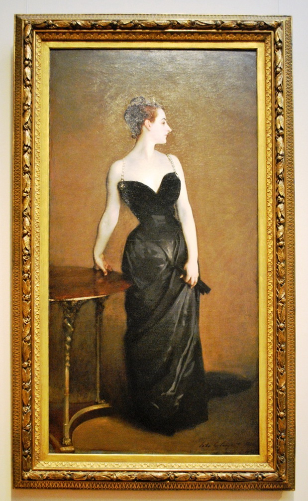 A woman standing near a table wearing a black dress