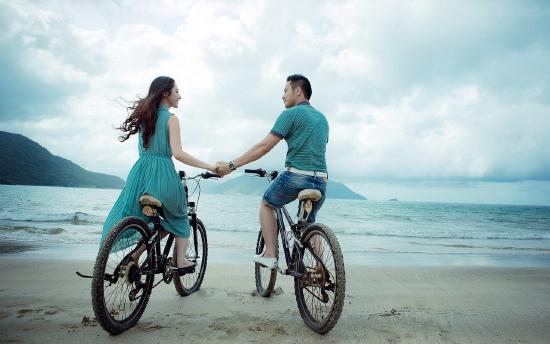 Couple riding bikes on a beach