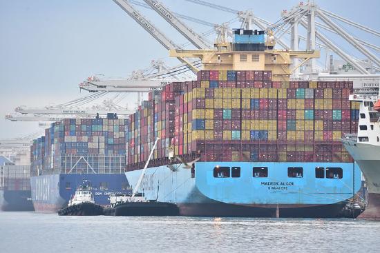 a large ship stacked high with colorful shipping containers