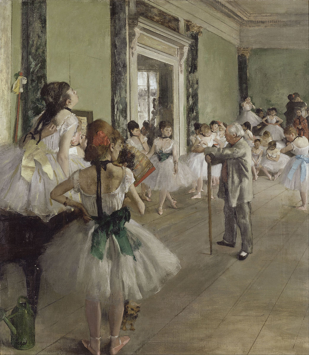 Inside a dance studio with several ballet girls and a man who is incharge 