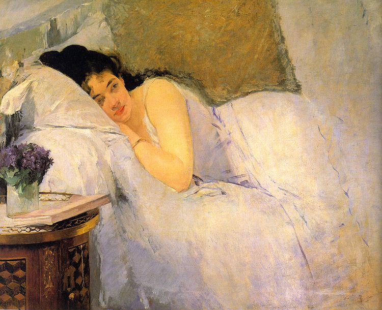 A woman dressed in white laying in bed with white covers