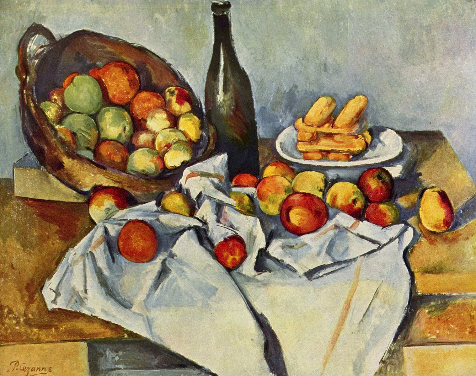 A table with a white draped cloth with a basket of fruit, a wine bottle and a plate of dessert