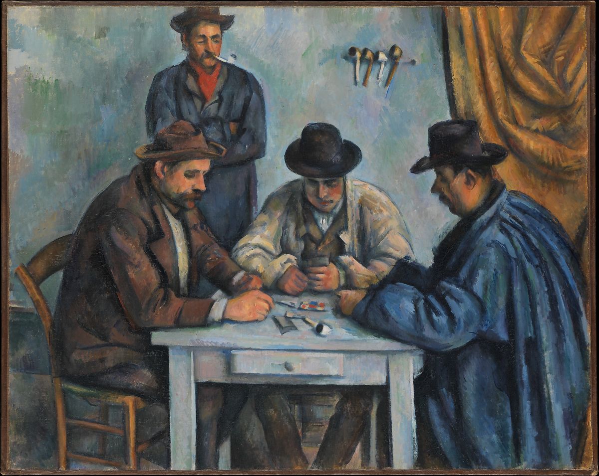 Three men sitting around a table playing a game while one is standing up watching