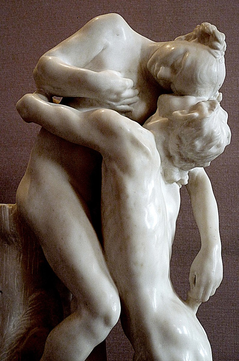 Two people carved from stone in an embrace