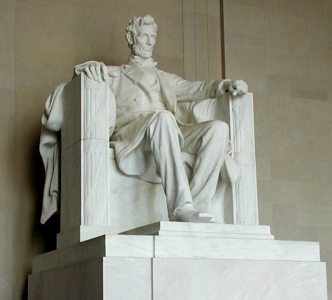 A large marble statue of a man sitting in a large chair 
