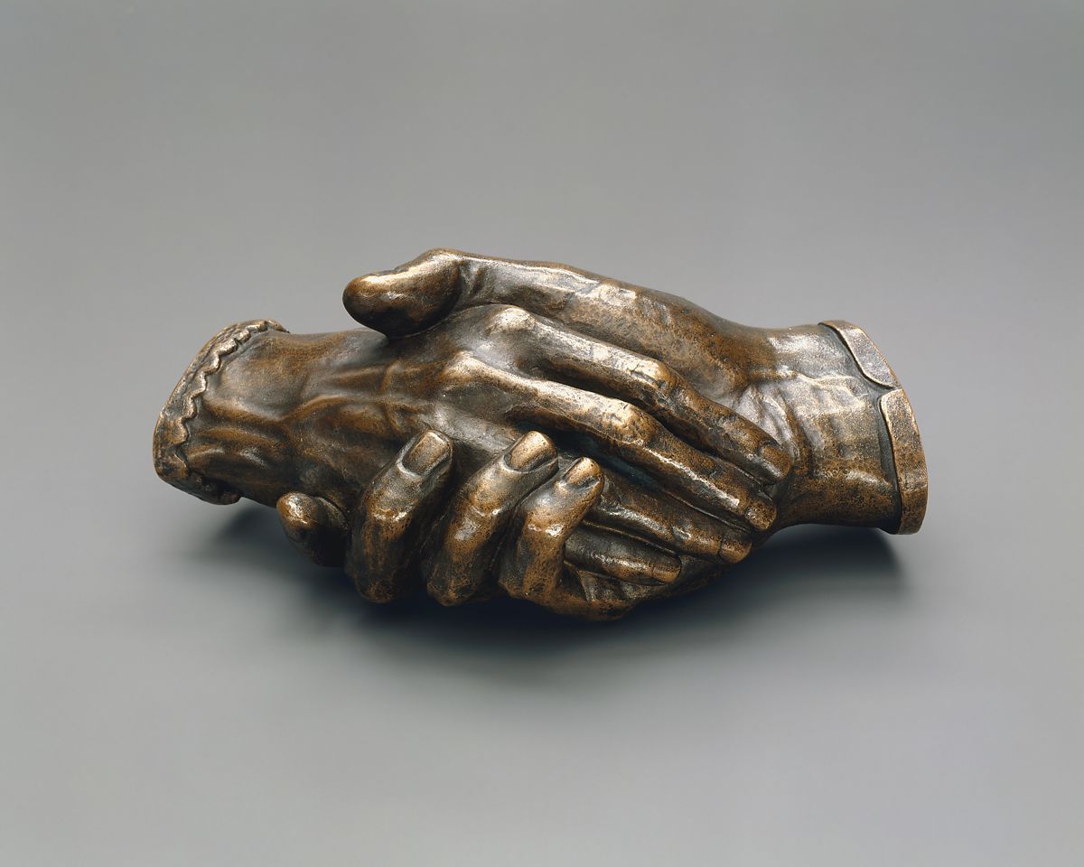 a pair of bronze hands casted together