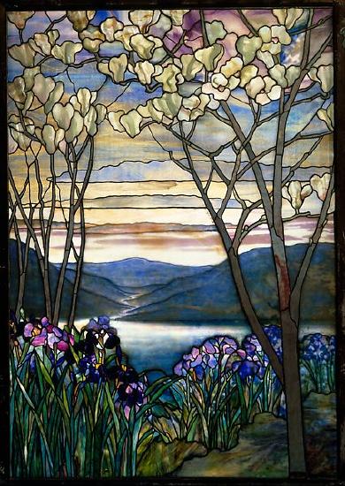 Stained glass window of a landscape of mountains, trees, and a lake