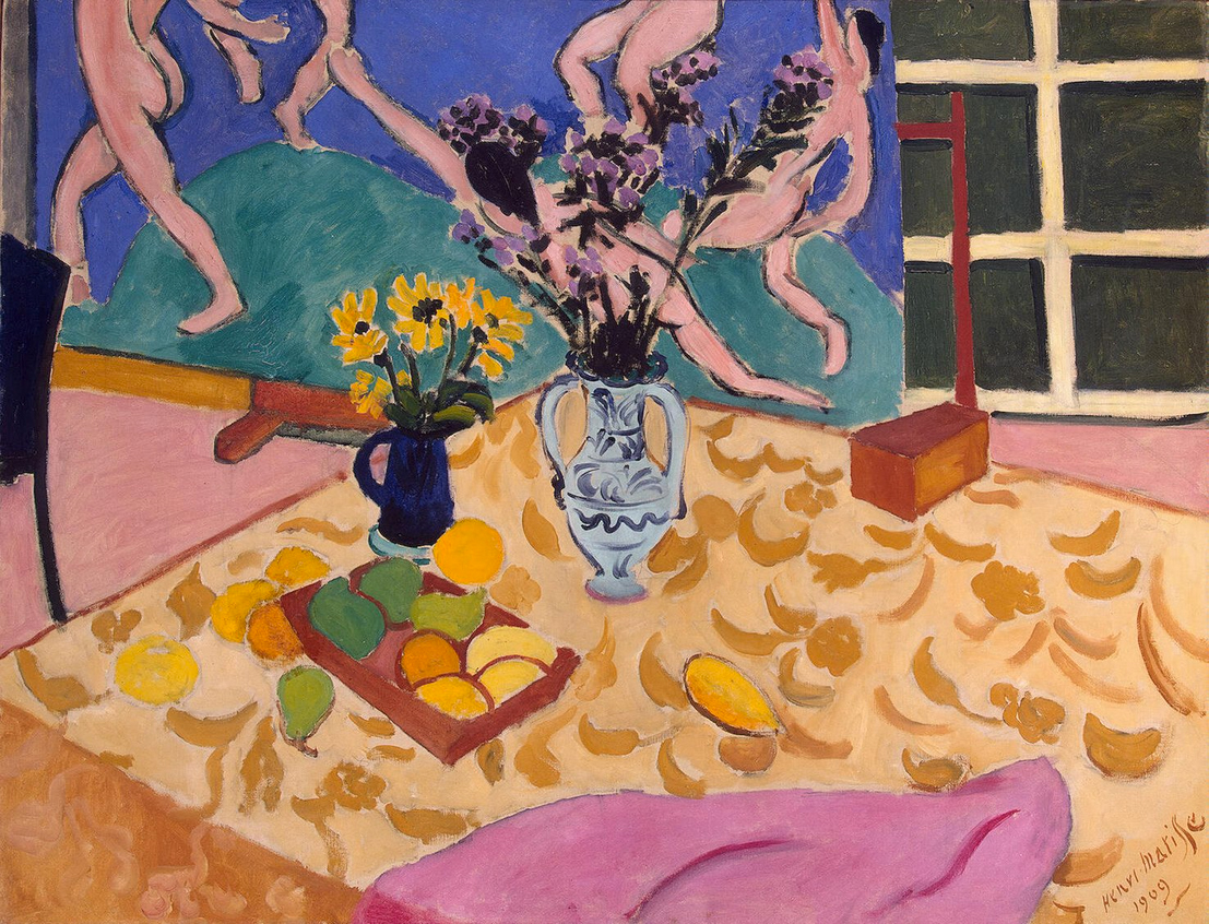 A table with fruit, flower vases and pink napkin with the five nude woman holding hands in a circle dancing on a green surface in the back ground