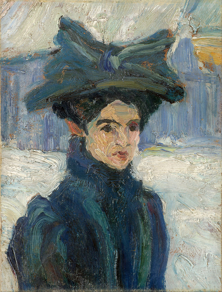 A woman wearing a dark blue coat and large hat with a bow in a winter landscape