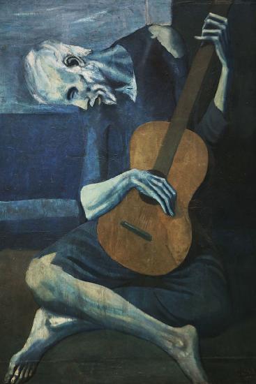 An older man playing a guitar wearing blue against a blue background