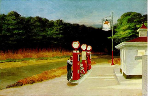 A red and white building with three gas pumps out front