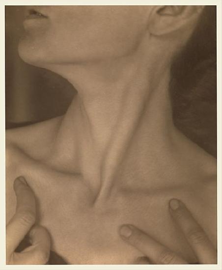A womans neck turned to one side and her fingers on her chest