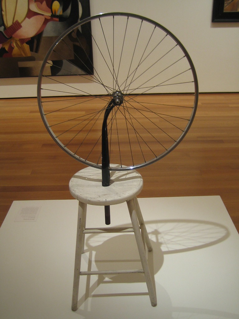 A bike wheel mounted on a white stool