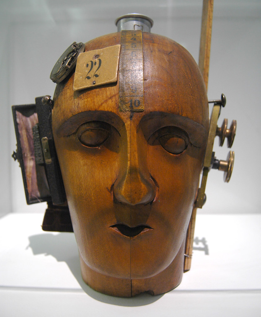 A wooden head with things attached to it