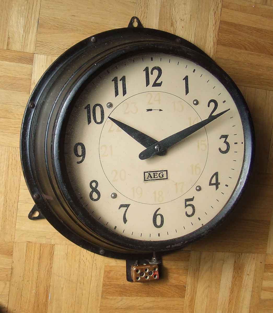 A wall clock with a white face and black numbers