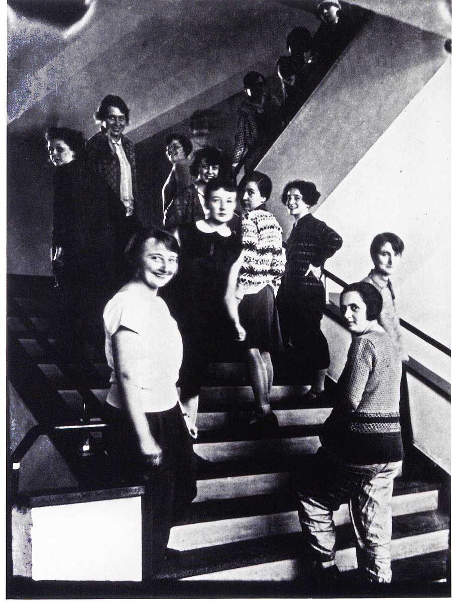 Several women standing on an interior staircase