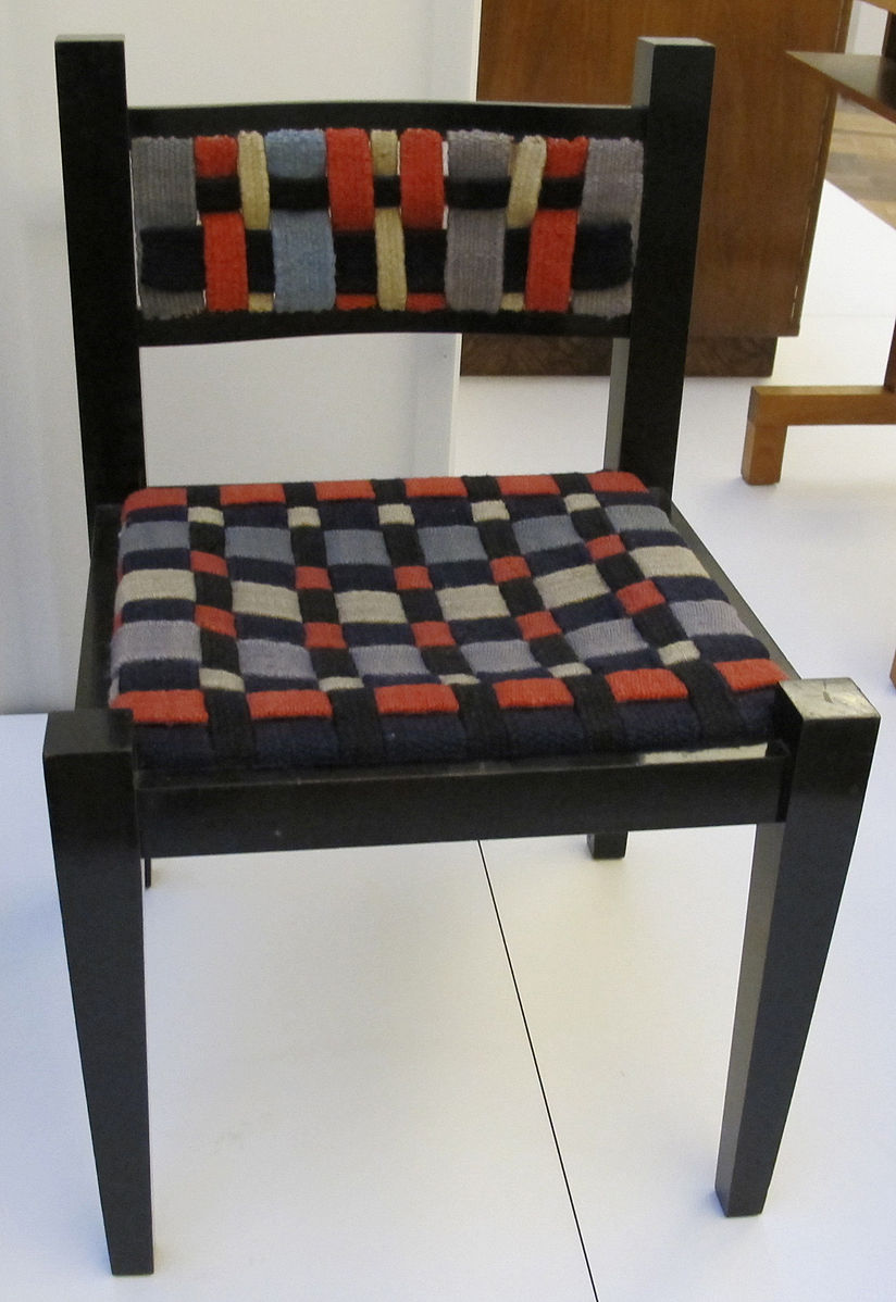 A chair with woven back and seat of wool colors