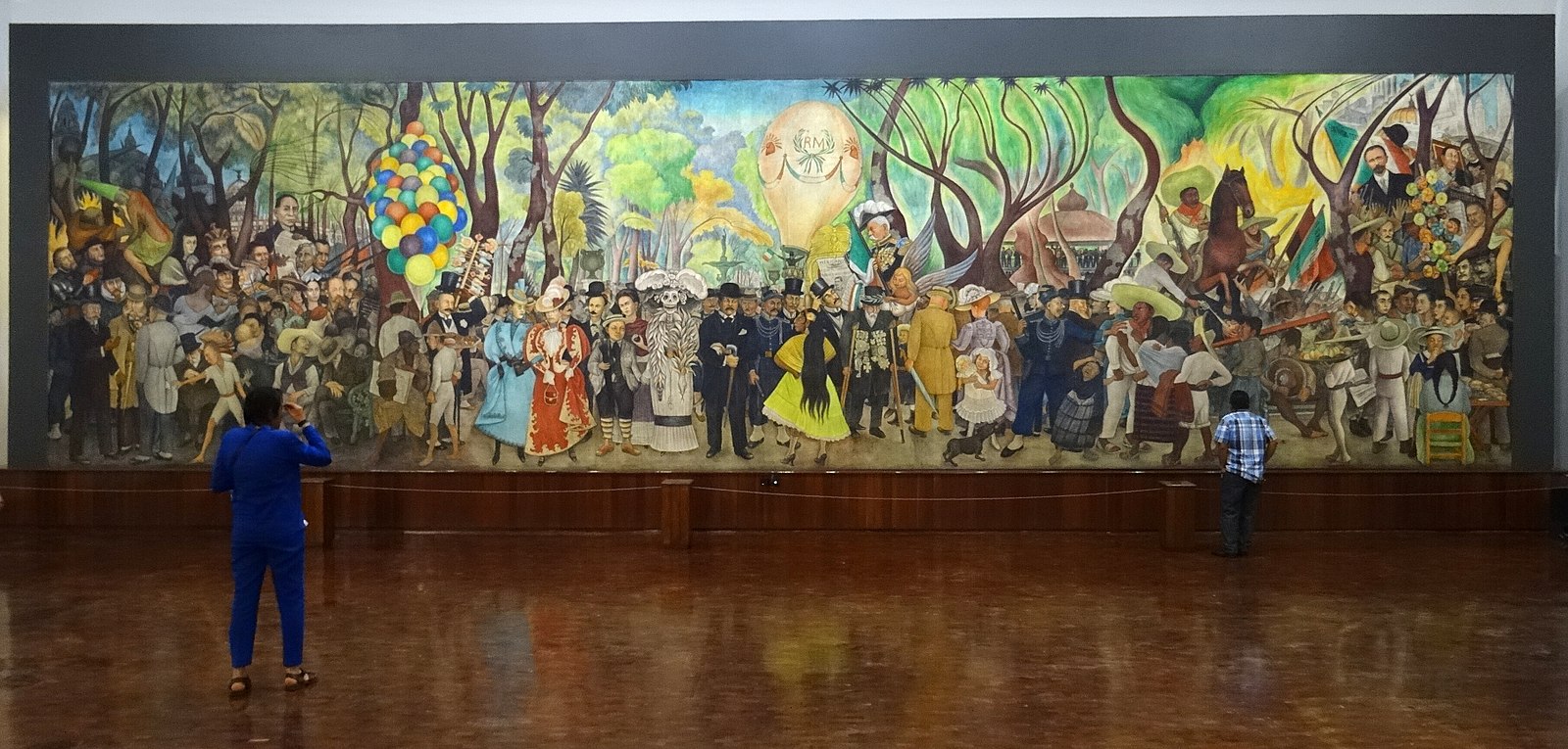 A large mural of an outdoor party scene with trees