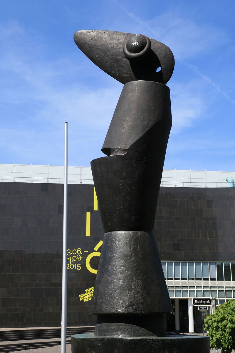 Escultura grande de piedra negra con cabeza y ojo grande
