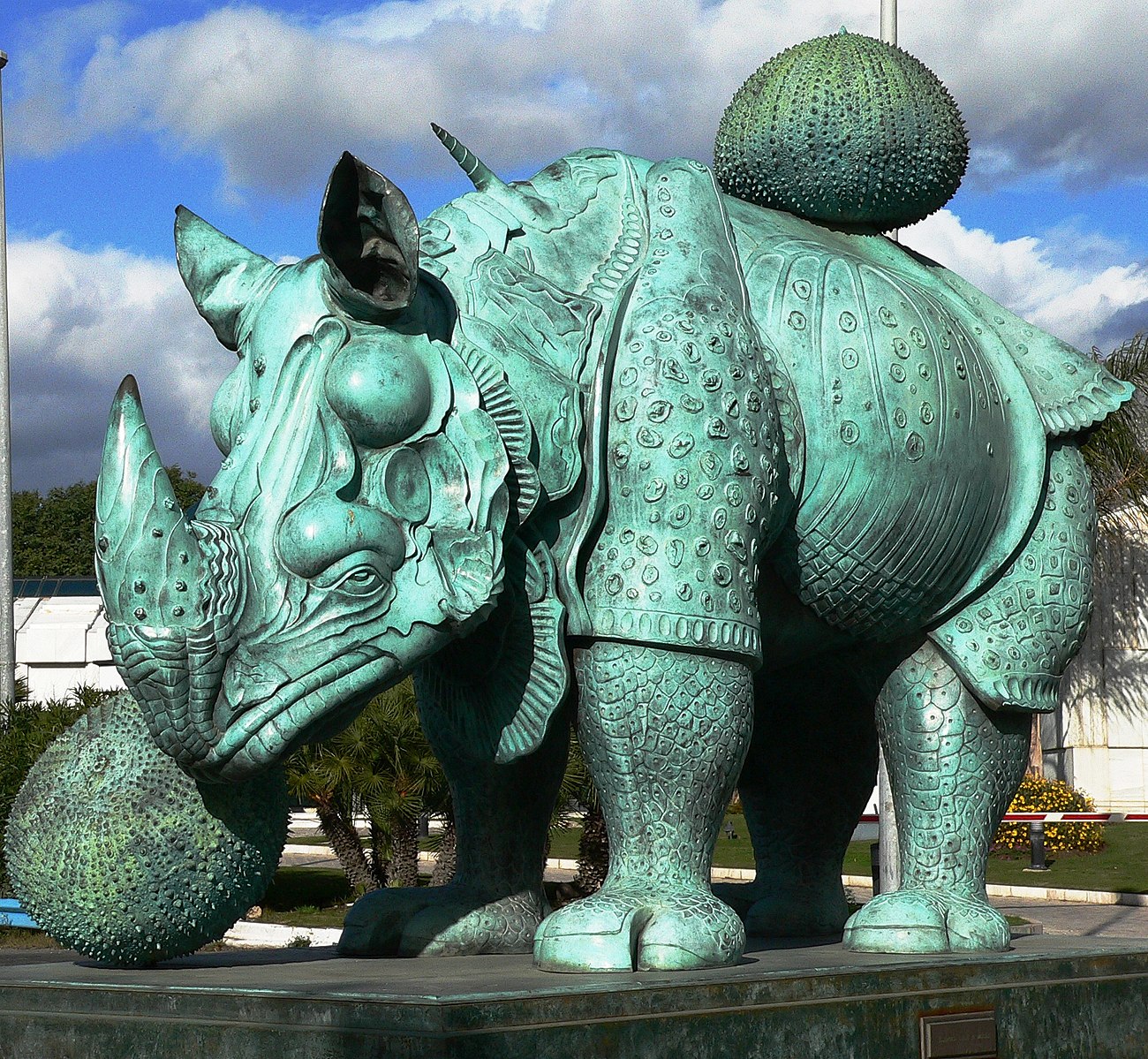 A large bronze sculpture of a rhinoceros with armor
