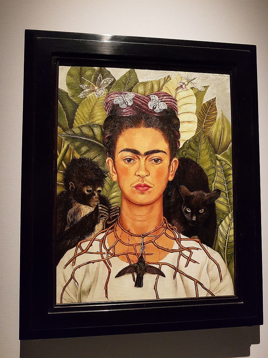 una mujer con camisa blanca con un collar de espinas y un pájaro en un ambiente tropical con un gato y un mono