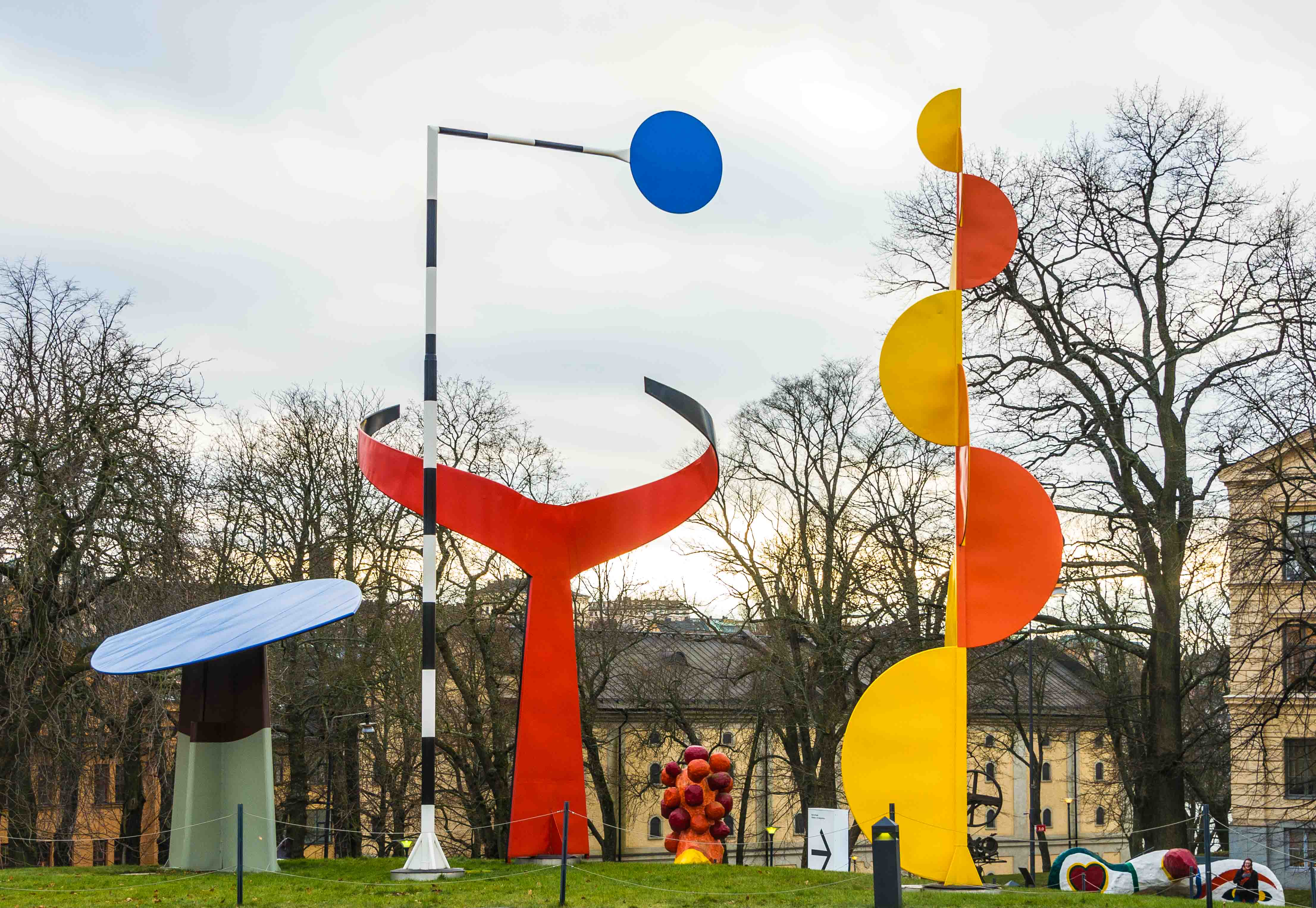 A large colorful multi shaped sculpture made of metal in a park 