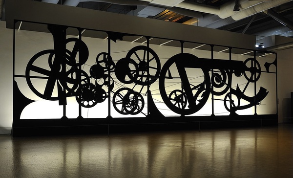 A large black metal sculpture made of bicycle parts