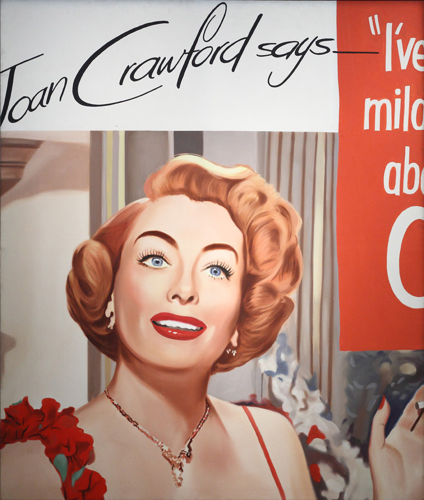 a womans bust with orange hair and blue eyes and red lips against drapes with text
